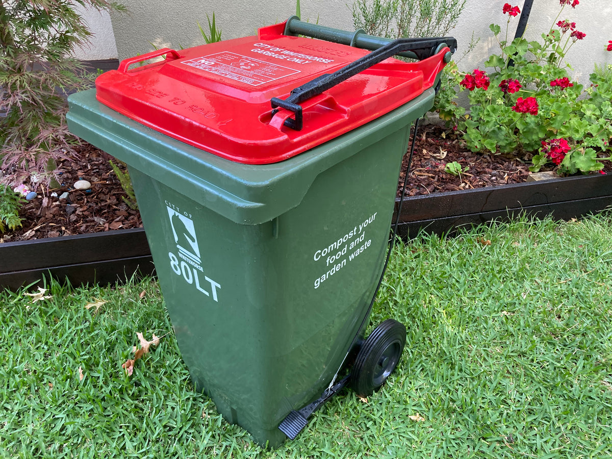 BLOP foot-operated bin lid opener fitted to a green 80L wheelie bin with a red lid, showing the pedal and lifting arm